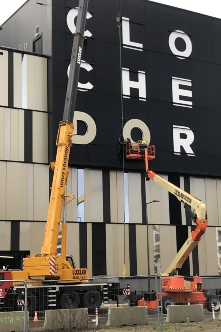 Grue mobile et nacelle articulée LUXLEV devant la façade du Cloche d'Or à Luxembourg