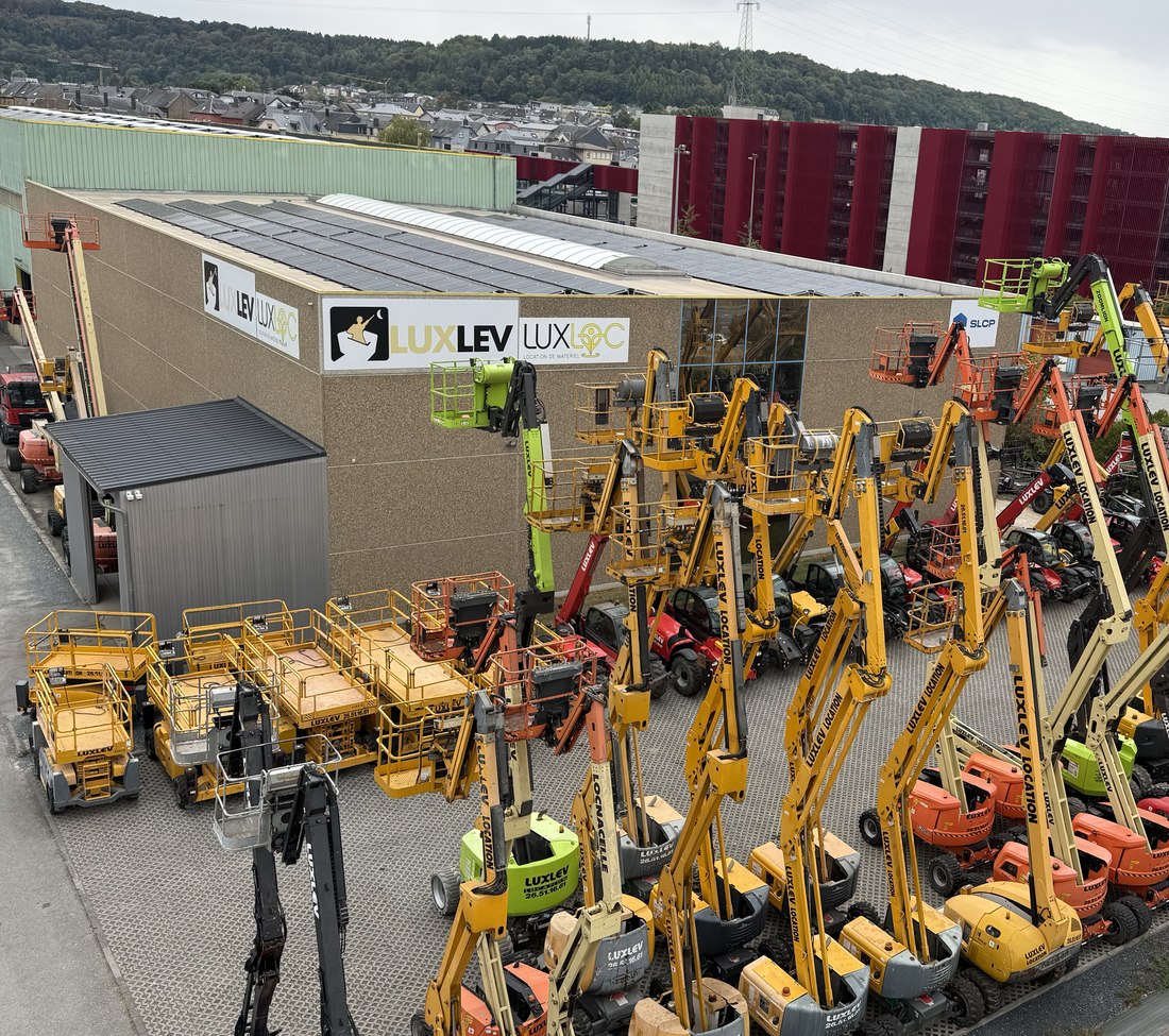Vue aérienne du dépôt LUXLEV à Pétange : nacelles articulées, ciseaux et chariots télescopiques alignés devant le bâtiment